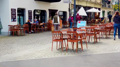 Street-in-Lucerne-of-Switzerland-with-table-settings,-people-dining-and-walking