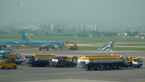 Scenery-Of-Trucks-And-Airplanes-Parked-At-Flight-Line-In-Gimpo-Airport-In-Seoul,-South-Korea