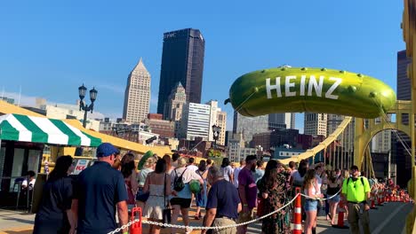 People-walking-on-Andy-Warhol-Bridge-with-giant-Heinz-pickle-balloon-in-the-background