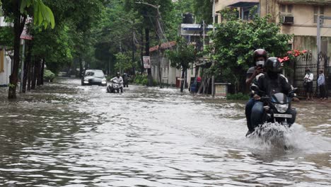 Fahrräder-Und-Autos-Bleiben-Bei-Heftigen-Regenfällen-In-Kalkutta,-Indien,-In-Einer-überschwemmten-Straße-Stecken