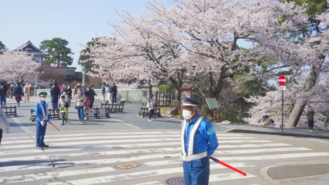 Traffic-Officers-In-Masks-Patroling-Kenrokuen-Garden-During-the-Sakura-Season---wide-shot