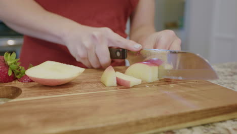 Woman-cutting-up-a-fresh-apple-on-cutting-board