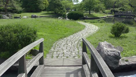 Kleine-Holzbrücke-über-Den-Teich-Mit-Steinpflaster-Im-Roger-Williams-Park-In-Providence,-Rhode-Island,-USA