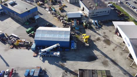 Company-Padøy-Transport-industrial-area-with-logo-and-machinery-parked-around---Sunny-day-aerial-overview-Asane-Bergen-Norway