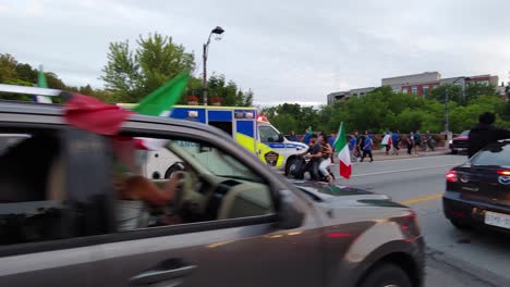 An-ambulance-rushing-on-a-road-with-crowds-of-Vaughan-fans-celebrate-Italy's-soccer-success