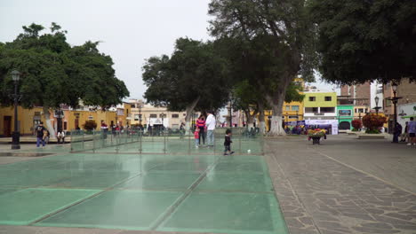 Tourists-on-vacation-and-a-Little-kid-walking-around-the-center-of-El-Recreo-Plaza,-Trujillo,-La-Libertad,-Peru