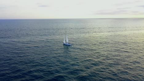 Flying-towards-a-sailboat-during-golden-hour-sunset-in-the-Pacific-Ocean-off-the-coast-of-Marina-Del-Rey-California