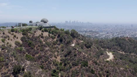 Aerial-dolly-in-shot-of-Griffith-Observatory-in-foreground-and-Los-Angeles-skyline-in-background