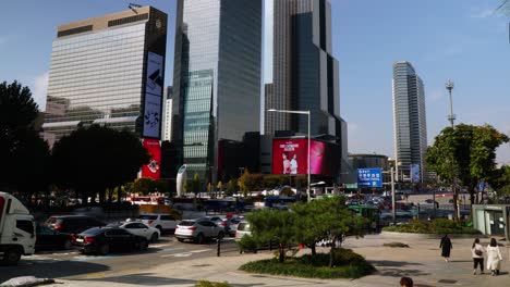 Samseong-station-traffic-and-crowd-of-people-with-High-raised-Coex-towers-urban-Seoul-skyline---static-time-lapse