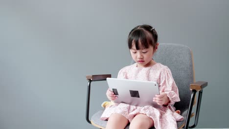 Child-watching-digital-tablet-and-looking-at-cheerful-camera