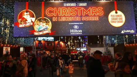 People-moving-in-and-out-of-the-Christmas-market-at-Leicester-Square-in-London,-UK