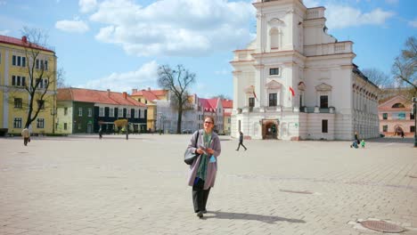 Old-Female-Tourist-Walking-On-The-Courtyard-Of-Town-Hall-Of-Kaunas-Old-Town-In-Lithuania