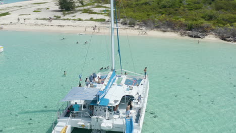 AERIAL---Catamaran-boat-on-clear-waters,-Cayo-Icacos,-Puerto-Rico,-spinning-shot