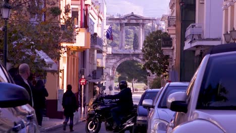 Cars-through-the-streets-of-Athens,-Greece,-with-a-monument-background