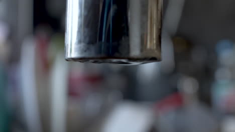 Slow-Drip-From-End-Of-Faucet-Tap-With-Bokeh-Background