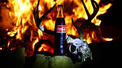 Dies-Ist-Ein-Statisches-Video-Einer-Coca-Cola-Flasche-Vor-Einem-Feuer-Und-Einem-Hirschschädel