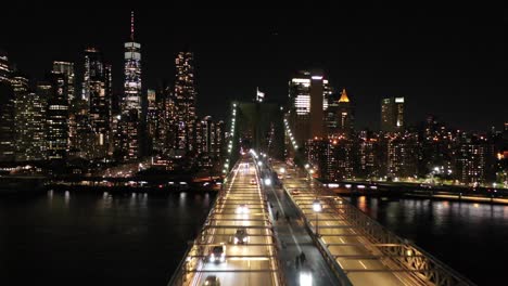 Eine-Langsame,-Niedrige-Drohnenaufnahme-Der-Skyline-Von-New-York-Von-Der-Brooklyn-Bridge-Bei-Nacht