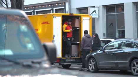 People-receive-packages-from-the-delivery-car-in-Munich