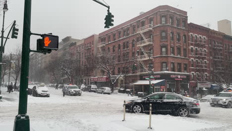 Car-Spins-Tires-On-New-York-City-Street-With-Police-Cars-Passing-By-In-Heavy-Snow