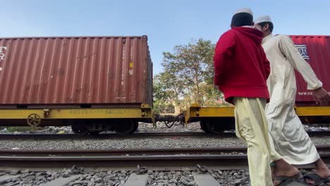 Transporte-De-Contenedores-De-Carga-En-Tren-De-Carga-Que-Pasa-Con-Gente-Bengalí-Caminando