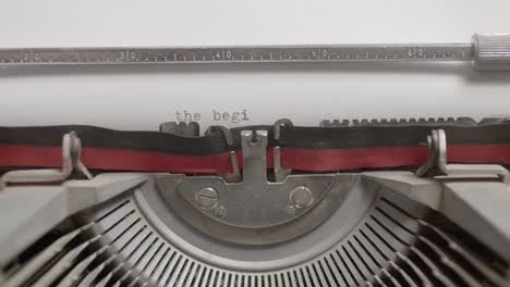Closeup-of-a-typewriter-machine-writing-The-Beginning