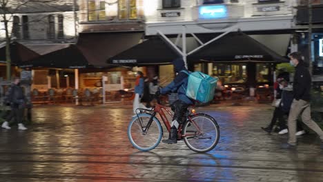 Deliveroo-Rider-Arriving-with-Electric-Bike-at-Restaurant-to-Pick-up-Food-Orders-and-Deliver-Orders-for-Clients-and-Customers---Ghent,-Belgium