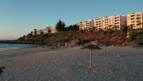 Luftaufnahme-über-Dem-Leeren,-Bei-Sonnenuntergang-Beleuchteten-Strand-Von-Tongoy-In-Puerto-Velero-Mit-Resorthotels-Im-Hintergrund-In-Chile