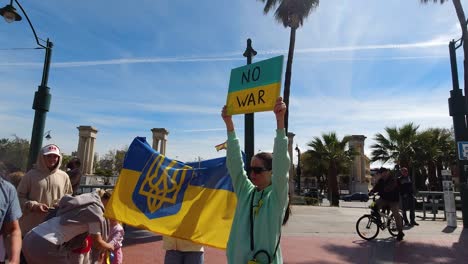 Frauen-Halten-Bei-Einer-Friedenskundgebung-Ein-„Kein-Krieg“-Schild-Und-Eine-Ukrainische-Flagge-Hoch