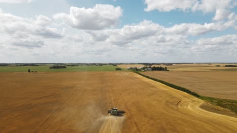 Combine-harvester-working-in-a-large-crop-of-golden-wheat-on-a-beautiful-sunny-day-in-the-rural-countryside