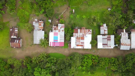 Aerial-view-moving-away-shot,-Scenic-view-log-cabins-in-the-amazon-forest-on-a-overcast-day-in-Colombia