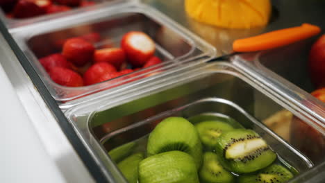Behälter-Mit-Zubereitetem-Obst,-Kiwis,-Erdbeeren,-Äpfeln,-Mango,-Nahaufnahme-Schieberegler-4K