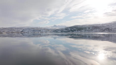Surface-of-water-in-fjord-is-dead-calm-with-perfect-reflection-of-sky