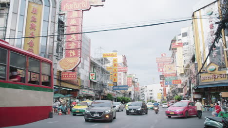 Bangkoks-Chinatown,-Busy-Bangkok-at-Daytime,-Busses-Taxis-and-Cars-passying-by-Yaowarat-Street