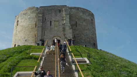 Tourists-climbing-the-stairs-to-the-newly-refurbished-Cliffords-Tower-Castle-Museum-York-on-a-bright-beautiful-day-England-UK