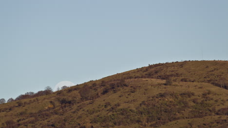Timelapse-of-the-Moon-rising-over-a-mountain-in-daytime