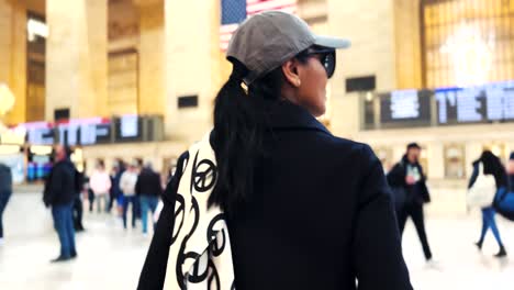 Affluent-Asian-woman-walking-through-Grand-Central-Station-hall-in-New-York-City-wearing-a-peace-scarf-and-enjoying-the-sights