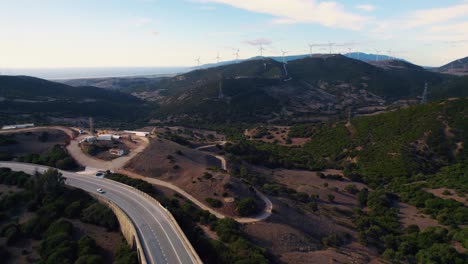 Drone-flight-at-sunset-with-cars-passing-along-the-highway-below-in-Tarifa,-Spain