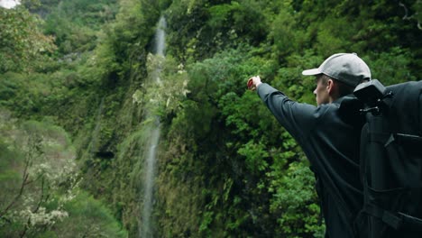 Hombre-Apuntando-A-La-Cascada-En-Madeira-Portugal