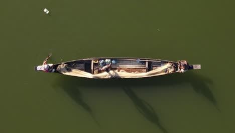 Fishermen-in-small-wooden-boat-row-on-dirty-river-in-Bangladesh