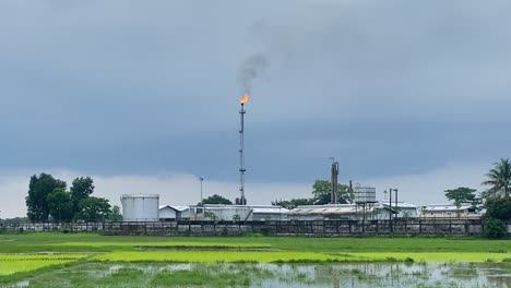 Gas-plant-with-grey-clouds-and-burning-gases-emitting-black-smoke