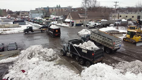 Dump-Trucks-Hauling-Loads-Of-Snow-At-The-Snow-Dump-Site-After-Extreme-Snowstorm-In-Buffalo,-New-York