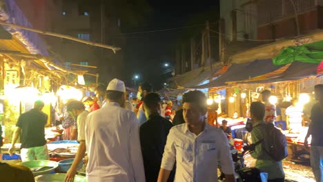 Schwenk-Eines-Geschäftigen-Und-Farbenfrohen-Nachtfischbasars-In-Bangladesch-Mit-Lebhaften-Lichtern-Und-Geschäftigem-Treiben