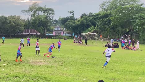 excitement-of-a-local-soccer-tournament-in-Bangladesh,-with-supporters-cheering-on-the-sidelines-and-creating-a-lively-and-energetic-atmosphere