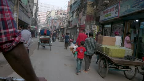 Blick-Aus-Der-Ersten-Person-Von-Einem-Rikscha-Beifahrersitz-Aus,-Während-Ein-Rikscha-Fahrer-Durch-Die-Straßen-Von-Dhaka-Fährt