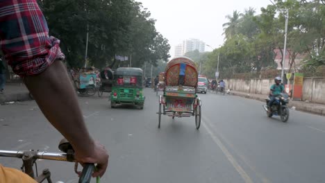 Blick-Aus-Der-Ersten-Person-Von-Einem-Rikscha-Beifahrersitz-Aus,-Während-Ein-Rikscha-Puller-Oder-Fahrer-Durch-Den-Verkehr-Auf-Den-Stark-Befahrenen-Straßen-Von-Dhaka-Fährt