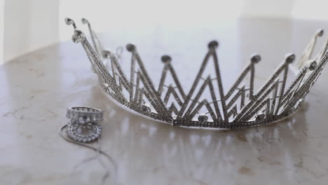Silver-crown-and-bridal-jewelry-for-the-bride's-wedding-on-the-table---pan-left