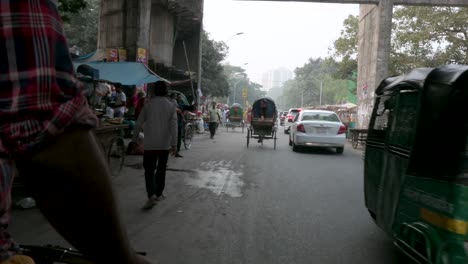 Blick-Aus-Der-Ersten-Person-Von-Einem-Rikscha-Beifahrersitz-Aus,-Während-Ein-Rikscha-Fahrer-Durch-Die-Verstopften-Straßen-Von-Dhaka-Fährt