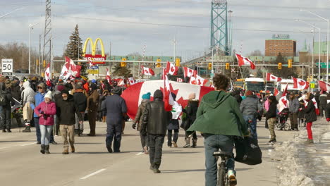 Riesige-Menschenmenge,-Die-Mit-Einer-Riesigen-Kanadischen-Flagge-Unter-Einer-Demonstration-In-Windsor-Läuft