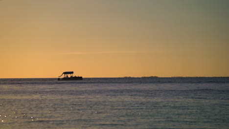 Pontoon-boat-on-a-sunset-cruise-in-the-Florida-Keys,-silhouette-with-water-bird