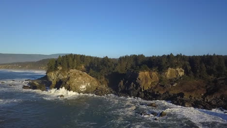 Wide-aerial-drone-of-Sue-Meg-state-park-coastline-and-forests-with-crashing-waves